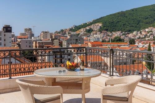 a table with a bowl of fruit on a balcony at Hotel Kadmo by Aycon in Budva