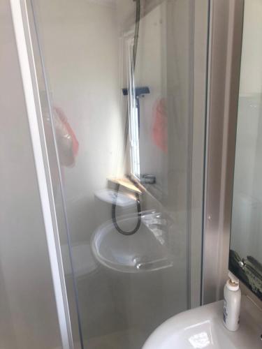 a bathroom with a toilet and a glass shower at Rockley Park in Lytchett Minster