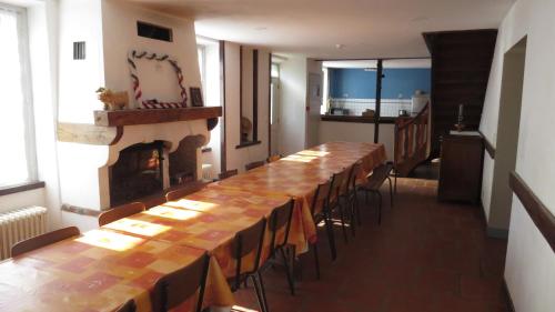 una mesa larga y sillas en una habitación con chimenea en Gite 20 places en Razès