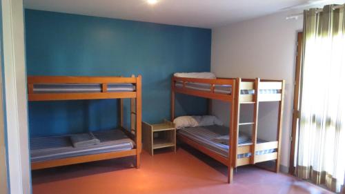 een kamer met 3 stapelbedden en een blauwe muur bij Gite 20 places in Razès