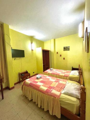 Habitación de hotel con 2 camas y TV de pantalla plana. en HOSPEDAJE GRAN PAJATEN, en Tarapoto