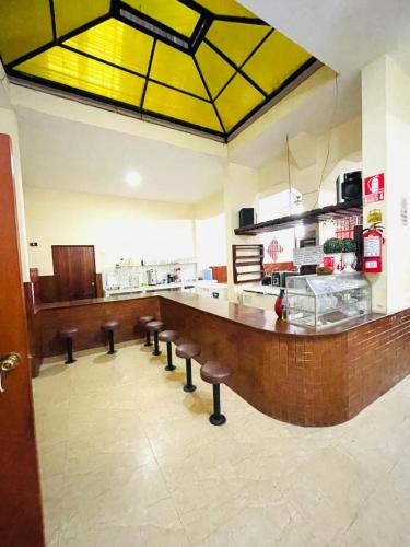 une grande cuisine avec un bar et des tabourets. dans l'établissement HOSPEDAJE GRAN PAJATEN, à Tarapoto