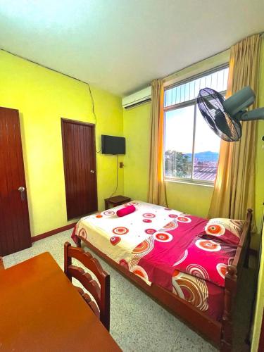 um quarto com uma cama, uma mesa e uma janela em HOSPEDAJE GRAN PAJATEN em Tarapoto