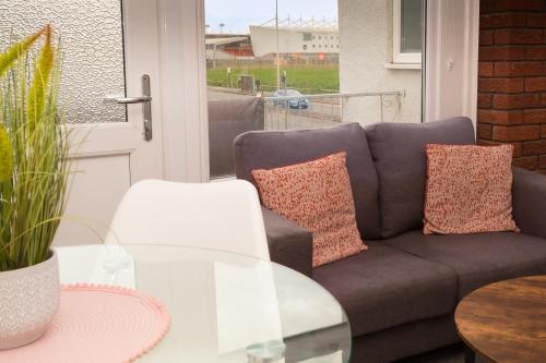 a living room with a couch and a glass table at Bloomfield Apartments in Blackpool