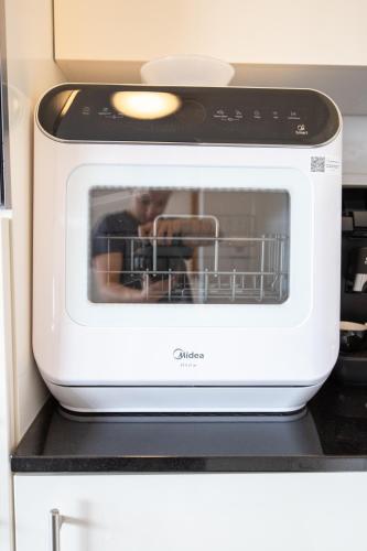 a microwave oven sitting on top of a kitchen counter at Special MODERN LiSA Apartment Basel, Bahnhof Grossbasel 10-STAR in Basel