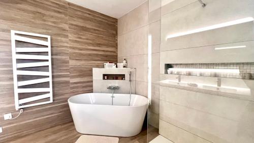 a bathroom with a white tub and a sink at Villa contemporaine bord de mer Saint Aygulf in Fréjus