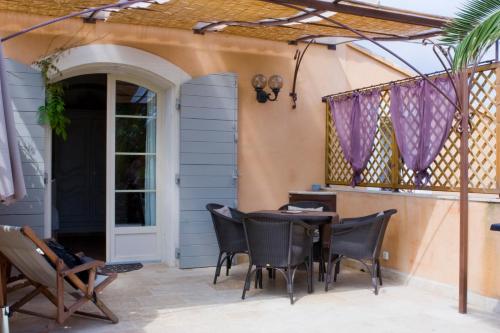 d'une terrasse avec une table, des chaises et une porte. dans l'établissement La treille, à Laouque