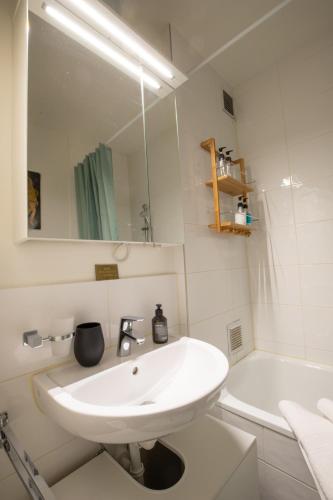 a white bathroom with a sink and a tub at Special MODERN LiSA Apartment Basel, Bahnhof Grossbasel 10-STAR in Basel