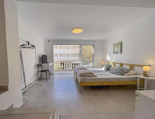 a bedroom with a large bed and a balcony at Burriana Casa Playa in Nerja