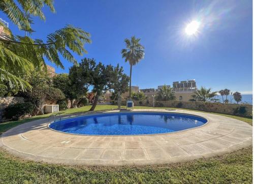 a large pool in a yard with palm trees at Burriana Casa Playa in Nerja