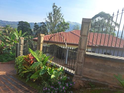 a fence in front of a house with flowers at Villa Valentine in Bana