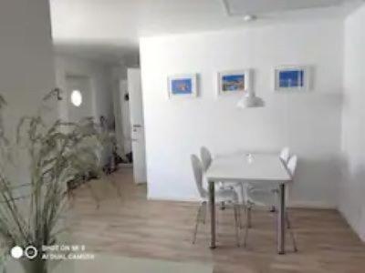 uma sala de jantar com uma mesa branca e cadeiras em Gästhus, 45m2, lugnt, havsbad em Särö