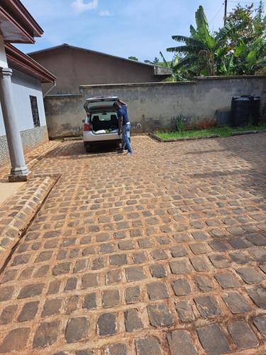 a man standing next to a car with its trunk open at Villa Valentine in Bana