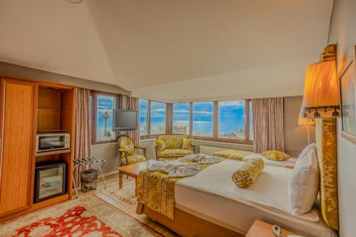 a bedroom with a large bed and a large window at Hotel Tashkonak Istanbul in Istanbul