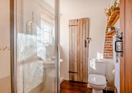 a bathroom with a toilet and a sink and a shower at Bakers Cottage - Sidestrand in Sidestrand