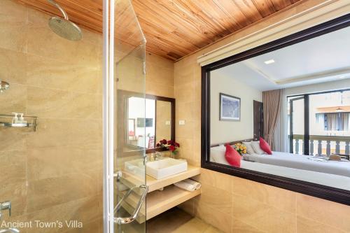 baño con ducha de cristal y cama en Dubai-Loius Residence en Hoi An