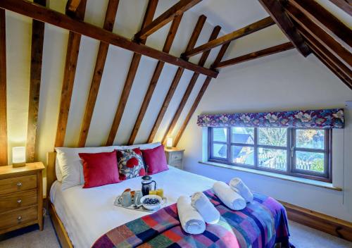 a bedroom with a bed with a tray of food on it at Holly Cottage in Panxworth