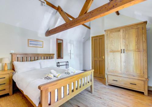 a bedroom with a bed and a wooden cabinet at Pond Cottage in Sidestrand