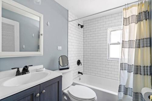 a bathroom with a sink and a toilet and a tub at Norwood Park/Edison Park! Workstation & In-unit Laundry! 2nd Floor Apt in Chicago