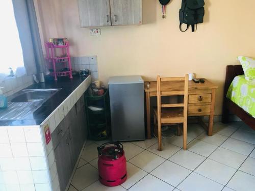 eine Küche mit einer Theke, einem Waschbecken und einem Schreibtisch in der Unterkunft lovely small home in Nairobi