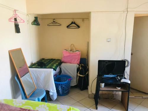 Zimmer mit einem Bett, einem Tisch und einem Spiegel in der Unterkunft lovely small home in Nairobi