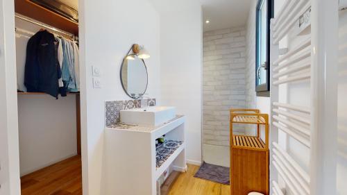 une salle de bain avec un lavabo et un miroir dans l'établissement Villa avec piscine au sel à 50 mètres de la plage, au Cap d'Agde