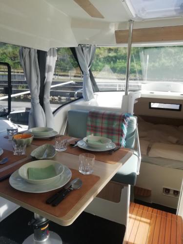 a table with plates and utensils on a boat at Koolhouse Boat in Vila Nova de Foz Coa