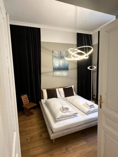 a bedroom with a bed and a chandelier at Kaiserin Sissi - City Apartment Downtown Vienna in Vienna