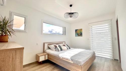 une chambre avec un lit et deux fenêtres dans l'établissement Villa contemporaine bord de mer Saint Aygulf, à Fréjus