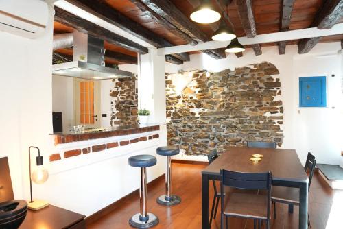 een eetkamer met een stenen muur en een tafel en stoelen bij Janua Major in Cernobbio