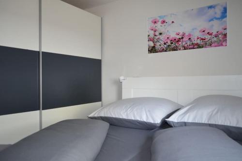 a bedroom with two beds and a painting on the wall at FeWo Nähe Bahnhof und Europa-Park in Ringsheim