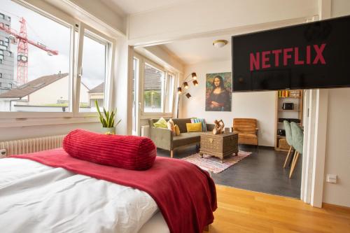 a bedroom with a bed with a netflix sign on the wall at Special MODERN LiSA Apartment Basel, Bahnhof Grossbasel 10-STAR in Basel