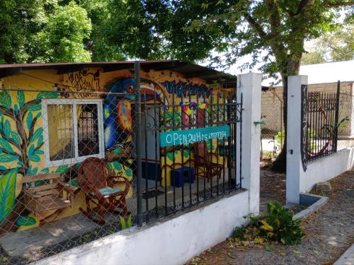 un bâtiment recouvert de graffiti avec une clôture dans l'établissement Taca Tucan, à Cruce del Farallón