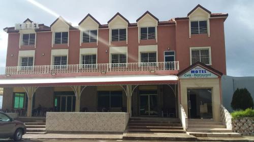 a large red building with a balcony on top at Hotel Opéra Azrou in Azrou