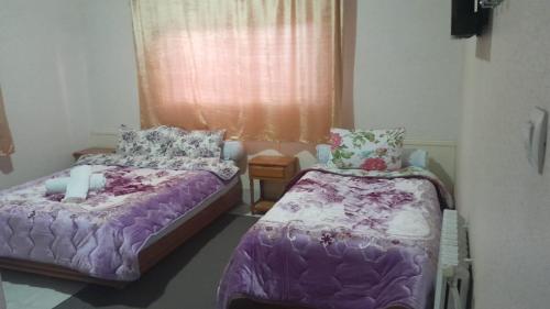 a bedroom with two beds and a window at Hotel Opéra Azrou in Azrou