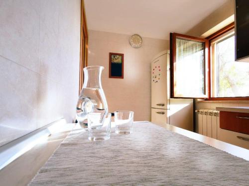 two glasses sitting on a kitchen table with a vase at Casa Tonino in Pisticci