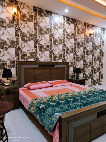 a bedroom with a bed and a wall with photographs at VIP Luxury Room's in Lahore