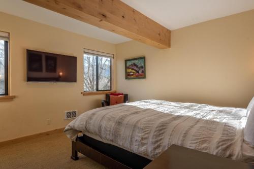 a bedroom with a bed and a flat screen tv at Cottonwood Condo 1474 in Sun Valley