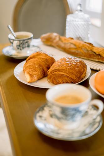 - une table avec des assiettes de pâtisseries et une tasse de café dans l'établissement Les Suites de la Cathédrale, à Albi