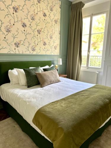 a bedroom with a large bed with a floral wallpaper at Château De La Bûcherie in Saint-Cyr-en-Arthies
