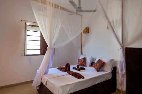 a bedroom with a bed with a ceiling fan at 1 NICOS LODGING in Dar es Salaam