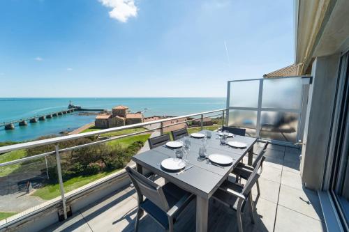 une table à manger sur un balcon avec vue sur l'océan dans l'établissement Emplacement Rare avec Vue Mer Garage fermé, à Les Sables-dʼOlonne