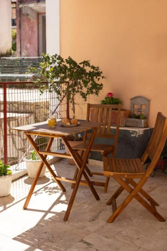 a wooden table and chairs with a tree on a patio at The Village Cottage - Benitses in Benitses