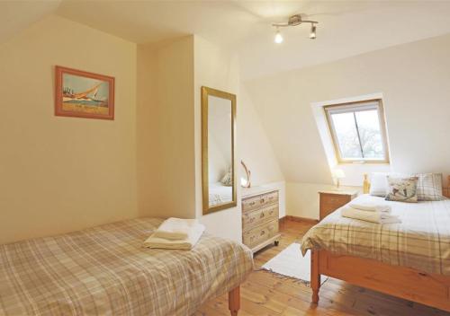 1 dormitorio con 2 camas, espejo y tocador en Ash en Lowestoft