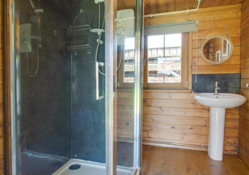 a bathroom with a shower and a sink at Old Cottage The Log Cabin in Bacton