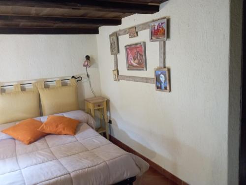 a bedroom with a bed and pictures on the wall at Torre Riva Dimora storica in Fiumalbo