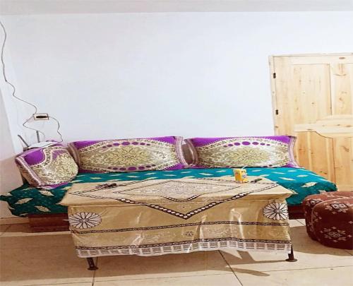 um quarto com um sofá roxo e uma mesa em A room in a shared house for surfers2 em Safi