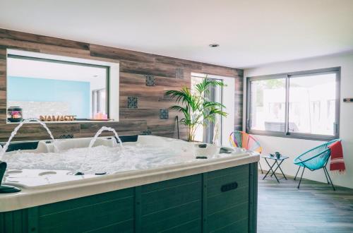 ein Badezimmer mit einer Badewanne und einem großen Spiegel in der Unterkunft Villa des Dunes in La Tranche-sur-Mer