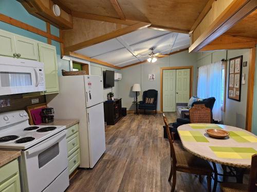 eine Küche und ein Esszimmer mit einem Tisch und einem Kühlschrank in der Unterkunft Frog Hollow at Hocking Vacations in Logan