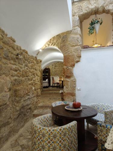 a room with a table and chairs and a stone wall at Del Centro in Enna
